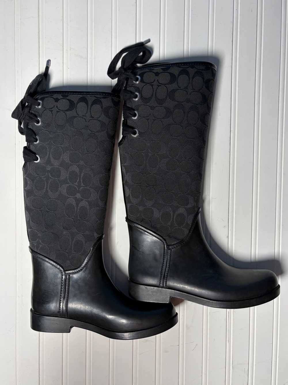Knee high Coach rain boots with lace up back
